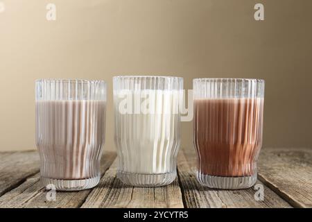 Verschiedene leckere Proteincocktails in Gläsern auf Holztisch Stockfoto