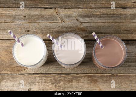 Verschiedene leckere Proteincocktails in Gläsern auf Holztisch, oben Stockfoto