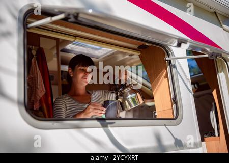 Frau kocht im Wohnmobil, Wohnmobil-Innenraum Stockfoto