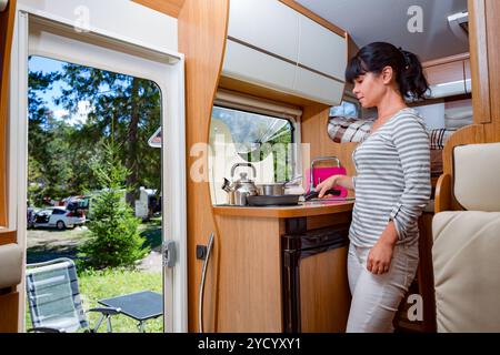 Frau kocht im Wohnmobil, Wohnmobil-Wohnmobil-Innenraum Stockfoto