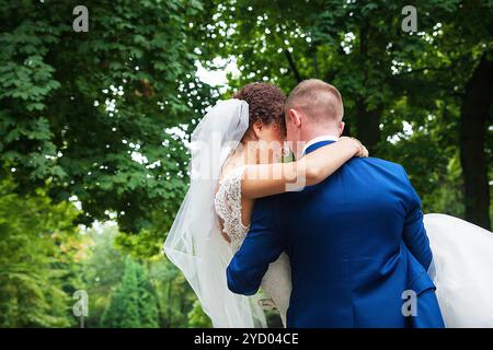 Bräutigam hält seine schöne und glückliche Braut Stockfoto