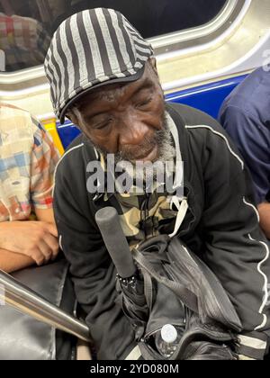 Müder Mann fährt zur abendlichen Hauptverkehrszeit in Manhattan, New York City, in einer überfüllten U-Bahn. Stockfoto