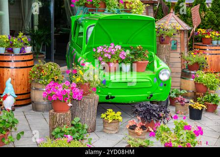 Blumenkomposition mit grünem Retro-Auto Stockfoto