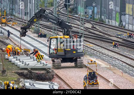 Schieneninfrastruktur, 23.10.2024 Arbeiter sind auf einer Baustelle am Grenzbahnhof weil am Rhein/Basel beschäftigt, um Betonschwellen für die Schieneninfrastruktur zu verlegen. Ein Bagger hebt Bauteile an, während mehrere Bauarbeiter in orangenen Schutzanzügen die Arbeiten koordinieren. Die Szene symbolisiert die Bemühungen, den Investitionsrückstau im deutschen Schienennetz durch Modernisierungen zu beheben. Weil am Rhein Friedlingen Baden-Württemberg Deutschland *** Bahninfrastruktur, 23 10 2024 Arbeiter sind auf einer Baustelle am weil am Rhein Basel Grenzbahnhof beschäftigt und legen auf Stockfoto