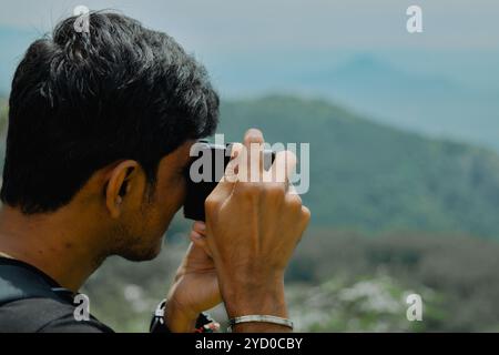 Ein junger Fotograf fängt die atemberaubende Schönheit einer Berglandschaft ein und findet seinen Fokus. Stockfoto