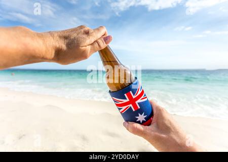 An einem warmen, sonnigen Sommertag können Sie ein kaltes Bier am Strand aufmachen. Abkühlen. Bierflasche in Kühlbox mit australischer Flagge Stockfoto