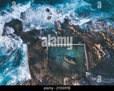 Aus der Vogelperspektive auf die Wellen rund um den Curl Curl Rock Pool Stockfoto