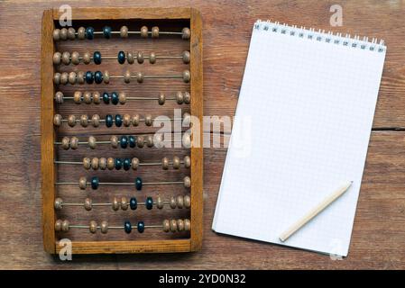 Abacus mit Notizblock und Bleistift auf Vintage Holztisch Stockfoto