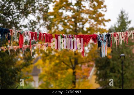 Installation von recyceltem Garn über der Straße. Hängende Außendekoration aus Wollgarn. Herbst Hintergrund. Stockfoto