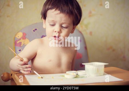 Der junge malt auf Papier. Rote und gelbe Farbe. Aktivitäten für Kinder. Kinder- Hobby. Zeichnung Stockfoto