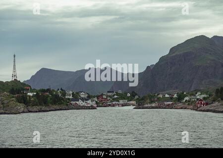 Ein ruhiger blick auf die Lofoten-Inseln in Norwegen, mit einer bezaubernden Stadt an der Küste mit felsigen Bergen, die majestätisch im B aufsteigen Stockfoto