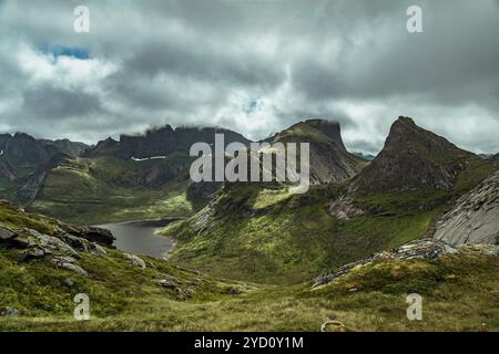 Erkunden Sie die atemberaubende Landschaft der Lofoten-Inseln in Nordland, Norwegen, wo majestätische Berge auf grüne Täler und ruhige Seen treffen. Ein Paradies für Stockfoto