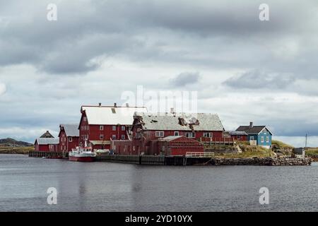 Eingebettet in die malerischen Lofoten Inseln, bieten farbenfrohe Cottages einen ruhigen Hafen, wo Fischerboote liegen, eingerahmt von dramatischen Wolken und einem pict Stockfoto