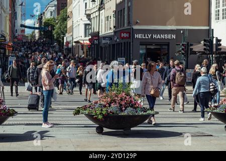 Oslo, Norwegen - 18. August 2018: Geschäftige Einkaufsstraße in der Innenstadt von Oslo mit einer jungen Frau am Telefon inmitten von Menschenmassen Stockfoto