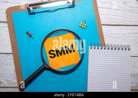 Eine weiße Haftnotiz mit dem Wort SMM in Rot befindet sich auf einem schwarzen Laptop-Bildschirm. Stockfoto