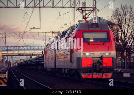 Die Lokomotive fährt bei Sonnenuntergang auf der russischen Eisenbahn. Russische Eisenbahn. Eisenbahn bei Sonnenuntergang. Russland, Leningrad, das Dorf Stockfoto