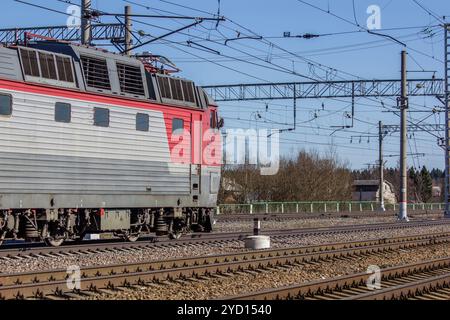Die Lokomotive fährt bei Sonnenuntergang auf der russischen Eisenbahn. Russische Eisenbahn. Eisenbahn bei Sonnenuntergang. Russland, Leningrad, das Dorf Stockfoto