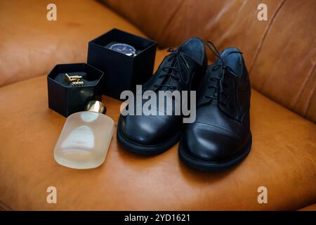 Elegante Herrenmode-Accessoires auf einem braunen Ledersofa. Stockfoto