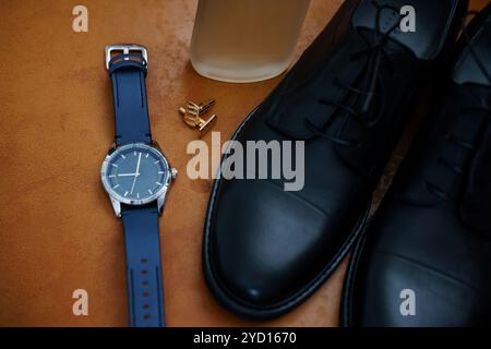 Elegante Herrenaccessoires mit schwarzen Kleidern, einer stylischen Uhr und goldenen Manschettenknöpfen. Stockfoto