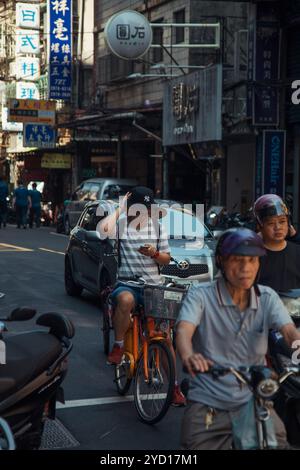 Taipeh, Taiwan - 10. Oktober 2019: Ein geschäftiger Nachmittag auf den Straßen Taipeis mit Radfahrern und Autos, die die Straße teilen Stockfoto