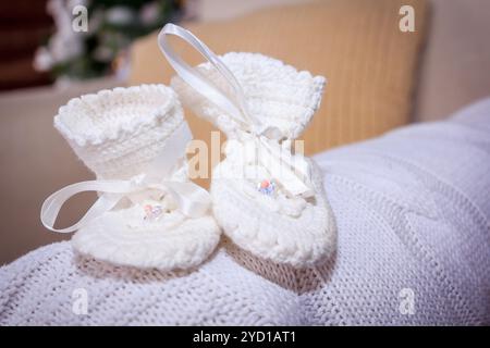 Weiße Schuhe für das Baby. Strickschuhe für das Baby. Wunderschöne Socken Stockfoto