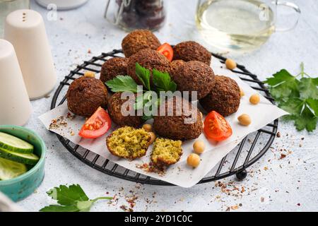 Stehen Sie mit köstlichen Falafelbällchen, Kichererbsen und Tomaten auf hellem Hintergrund Stockfoto