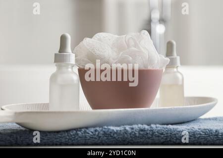 Kosmetikflaschen mit Luffa auf dem Tisch im Badezimmer, Nahaufnahme Stockfoto