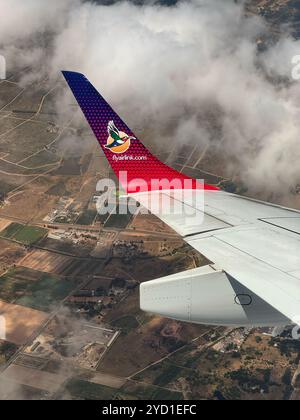 Kapstadt Westkap Südafrika. 15.02.2024. Blick auf Flügel und Winglet in einem Verkehrsflugzeug, das beim Anflug auf den Flughafen Kapstadt eine leichte Wolke überquert. Stockfoto