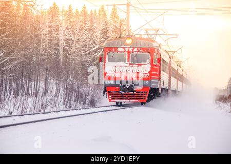 Russischer Zug im Winter. Der Zug fährt im Winter mit der Bahn in den Wäldern. Winterwald. . Russland Region Leningrad, Gatch Stockfoto