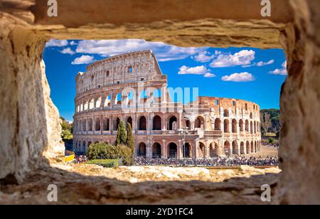 Panoramablick auf das Kolosseum von Rom durch ein Steinfenster Stockfoto