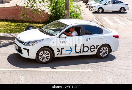 Uber Taxi fährt die Straße runter Stockfoto