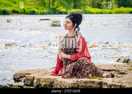 Frau auf den Wasserfällen. Kleiner Wasserfall. Camping. . Junge Frau. Frau in einem Kleid. Stockfoto