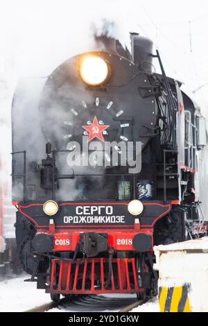 Alte Lokomotive fährt im Winter mit der Bahn. Öffentliche Verkehrsmittel. Personenbeförderung. Russische Lokomotive. Russische Eisenbahn. Russland Stockfoto