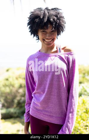 Lächelnde Frau genießt einen sonnigen Tag im Freien in lässigem Outfit Stockfoto
