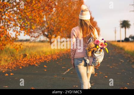 Frau, die im Herbst auf einer Landstraße läuft Stockfoto