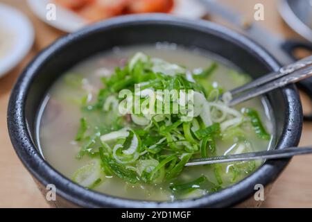 Schüssel Suppe mit grünen Zwiebeln und Fleisch. In der Schüssel befinden sich zwei Gabeln Stockfoto