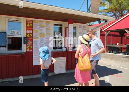 Eine Touristenfamilie, die von der umfangreichen Speisekarte bestellt wird. Bei Carriers hauptsächlich Lobster Pound Restaurant in Bucksport, Maine, USA. Stockfoto