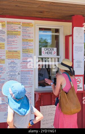 Eine Touristenfamilie, die von der umfangreichen Speisekarte bestellt wird. Bei Carriers hauptsächlich Lobster Pound Restaurant in Bucksport, Maine, USA. Stockfoto