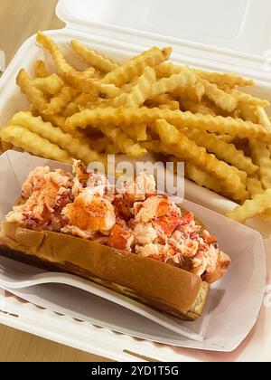 Die Standard-Hummerrolle auf einem gebutterten Hot Dog Brötchen im New England-Stil mit Crinkle geschnittenen Pommes frites. In Jordan's Snack Bar in Ellsworth, Maine, USA. Stockfoto