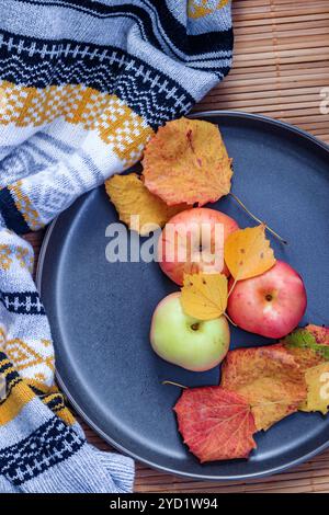 Teller mit Äpfeln. Herbstlayout. Obstäpfel. Herbstfoto. . Äpfel und Herbstblätter Stockfoto