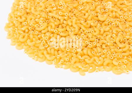 Ein Haufen ungekochter Chifferi Rigati Pasta auf weißem Hintergrund. Fett und ungesunde Lebensmittel. Klassische Trockene Makkaroni-Textur. Italienische Kultur und Küche. Rohe Pasta Stockfoto