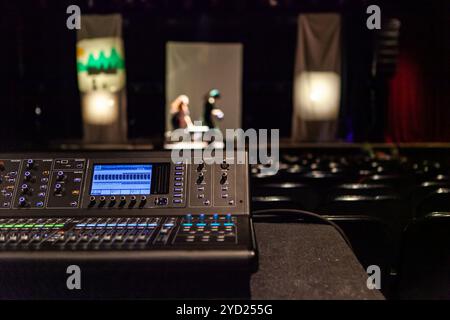 Eine Nahaufnahme der elektronischen Sound Equipment in ein Kindertheater, unscharfe Personen sind auf der Bühne im Hintergrund mit Kopie Raum gesehen Stockfoto