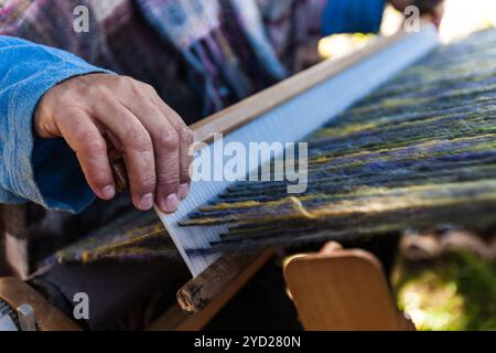 Mit einem Holzwebstuhl. Nahaufnahme mit den verschiedenen Farben der Wolle Stockfoto