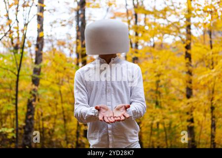 Ein Mann in weiß hat eine Kristallschale auf dem Kopf, während er Großzügigkeit zeigt Stockfoto