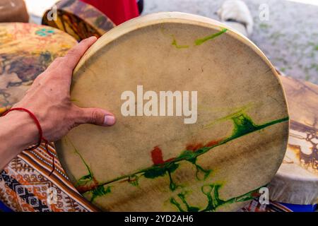 Bis auf die Hand des kaukasischen Mann hält die heilige Trommel schließen, neue farbenfrohe native american Leder drum während der Ausstellung im Freien Stockfoto