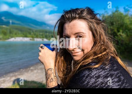 Erwachsene Frau trinkt draußen Kaffee Stockfoto