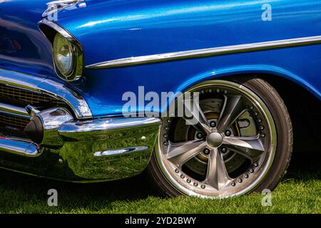 Alte antike klassische amerikanische blaues Auto vorne auf dem Gras mit einer verchromten Stoßfänger und Karosserie Teile, Vorderrad Seite Nahaufnahme, Sport star Felge Stockfoto