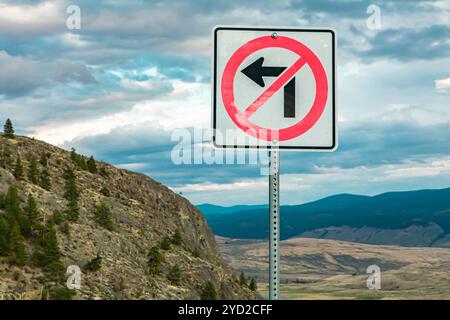 Nicht biegen Sie an der Kreuzung links ab, der Beschilderung, auf den Berg hoch und Straßen gegen die Natur, Berge und bewölkter Himmel Stockfoto