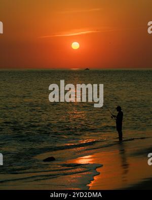 Ein Fischer in der Delaware Bay bei Sonnenuntergang, Cape May, New Jersey Stockfoto