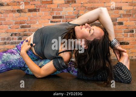 Gesunde Frau im fließenden Yoga-Kurs Stockfoto